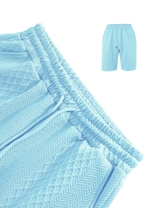 Detail of light blue knit shorts featuring diamond waffle texture and drawstring waist