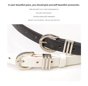 Close-up of minimalist black and white faux leather belts with silver horseshoe buckles