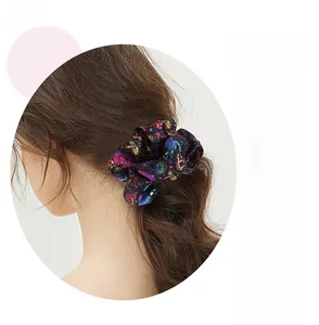 Detail of psychedelic pattern scrunchie with mushroom and eye motifs in a ponytail