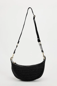 Detailed close-up of a black woven crescent bag with gold-tone hardware and adjustable strap