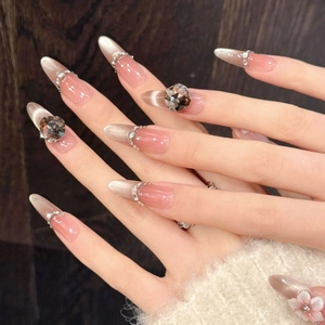 Faux ongles amande dégradé rose avec effet œil de chat argenté et fleurs 3D