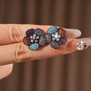 Vintage zircon flower earrings with colorful petals and black gold finish on fingertips