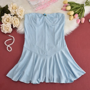 Flat lay of light blue strapless dress with pleated skirt and elegant pearl necklace