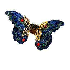 Vintage butterfly ring with blue embroidery and colorful crystals on a gold setting