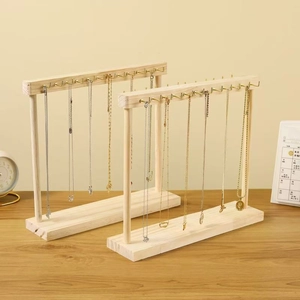 Close-up of wooden necklace display stands with metal hooks in a cozy home setting