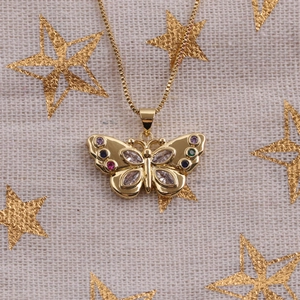Golden butterfly pendant necklace with colorful zircons on a festive star background