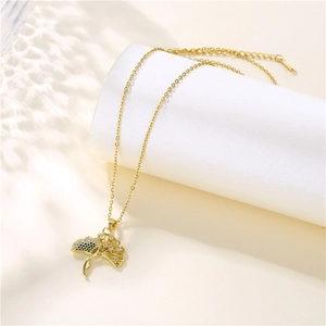 Elegant gold ginkgo leaf necklace with zircon micro-inlay on a white pedestal