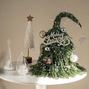 Mini sapin de Noël avec sommet courbé et lumières LED sur table avec boule à neige