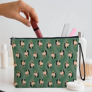 Green unicorn cosmetic bag with wristlet strap shown in use on a bright bathroom vanity