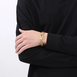Detailed view of golden twisted cable bracelet with decorative horseshoe buckle clasp
