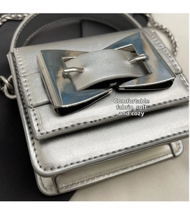 Close-up of the silver mini crossbody bag showing metallic buckle and chain strap