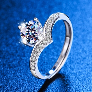 Macro di anello con diamante 1ct e fascia a V con pavé su sfondo blu effetto stella