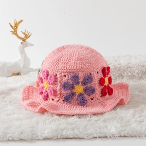 Pink handmade crochet bucket hat with 3D floral patterns on a soft white background