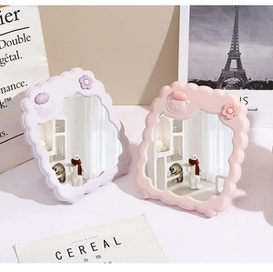 Pink and purple foldable cloud-shaped cartoon makeup mirrors on an INS style desk