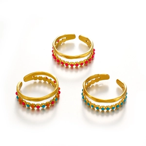 Three gold adjustable stackable rings with colorful enamel dots in blue pink and orange