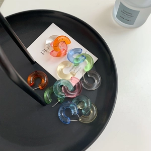 Close-up of assorted translucent jelly color acrylic C-shape hoop earrings on a tray