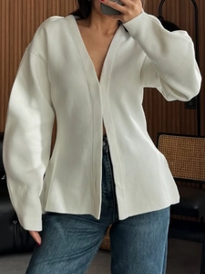 Close-up of a white knit V-neck cardigan featuring long sleeves and an open-front design