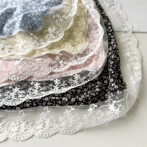 Detail of floral scarves with white lace borders in blue, yellow, pink and black