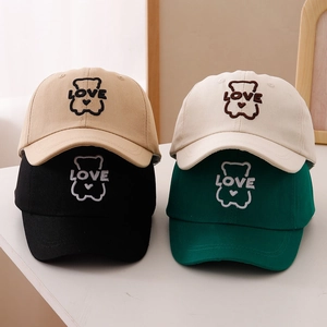 Detailed view of kids cotton baseball caps in four colors featuring bear heart embroidery