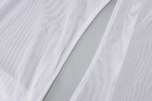 Gros plan macro montrant la texture en maille blanche et le tissu de la robe transparente