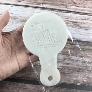 White plastic coffee stencil featuring Santa and sleigh cutouts for Christmas latte art