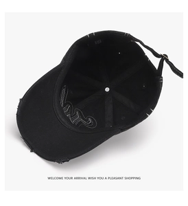 Close-up of black cotton baseball cap interior featuring frayed edges and metal buckle