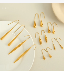 Vista macro di orecchini a goccia e a forma di zucca dorata su un piatto di ceramica