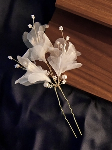 Detail of bridal hair pin with white tulle petals and elegant pearls on gold U-shaped pin