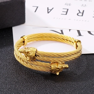 Detailed view of golden twisted cable bracelet featuring dual sculpted wolf heads motifs