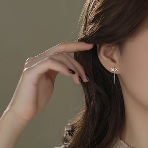 Elegant S925 sterling silver four-pointed star drop earrings worn by a model