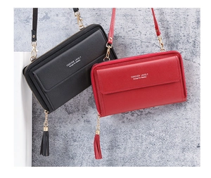 Detail of red and black leather crossbody mini bags with gold hardware and tassel accents