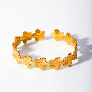 Detailed view of 18k gold plated stainless steel bracelet with floral leaf pattern