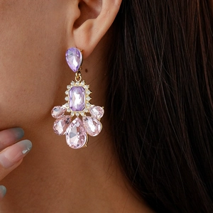 Vintage chandelier earrings with purple and pink crystals in gold plating worn by model
