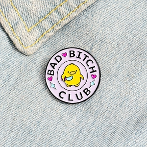 Macro shot of Bad Bitch Club duck enamel pin with blue knife detail on denim fabric