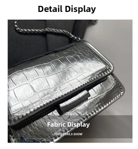 Detail of silver crocodile pattern mini bag with metallic finish and fine chain strap
