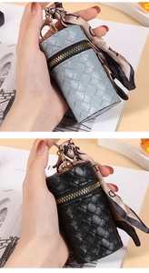 Detail of woven cylinder mini pouch in grey and black with floral scarf and gold clasp