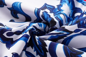 Detailed macro view of baroque floral print on white and blue backless swimsuit fabric