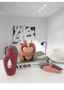 Detail of modern Morandi abstract ceramic figurines set on a minimalist bookshelf