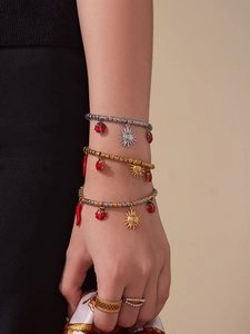 Detailed view of stacked beaded bracelets with ladybug charms and elegant metal rings