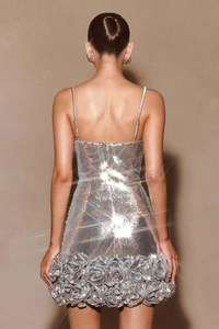 Detail of silver sequin mini dress featuring 3D floral accent and thin back straps