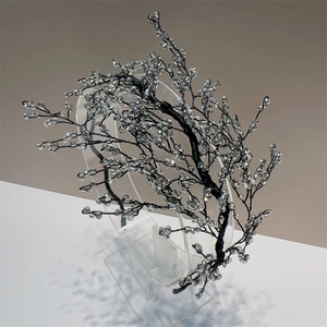 Detail of handcrafted black wire headband with clear crystal beads on acrylic stand