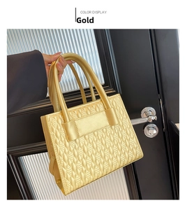 Detailansicht der goldenen Handtasche mit einzigartiger 3D-Blatt-Steppung und Griffen