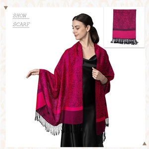 Detailed view of paisley jacquard scarf in magenta and black with elegant tassel trim