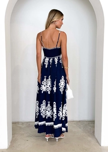 Detail of bohemian navy maxi dress featuring open back design and ethnic white floral print