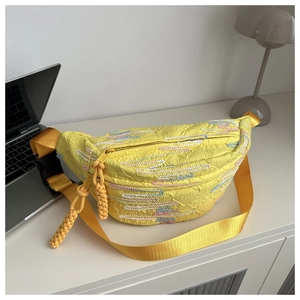 Close-up of bright yellow textured crossbody bag with thick rope zipper detail and woven strap