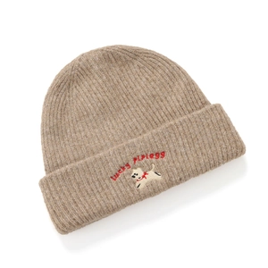 Close-up of beige knit beanie showing puppy embroidery and Lucky letter text detailing