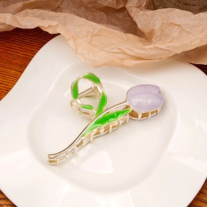 Detailed view of tulip hair claw clip with green leaves and purple flower in a ceramic tray