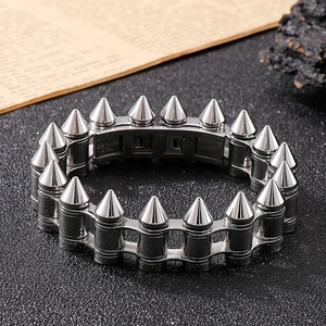 Detail of silver stainless steel bullet stud chain bracelet on black textured surface
