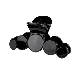 Glossy black PS material hair claw clip with unique circular design on white background