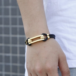 Men's braided black leather bracelet with a polished gold horseshoe metal buckle